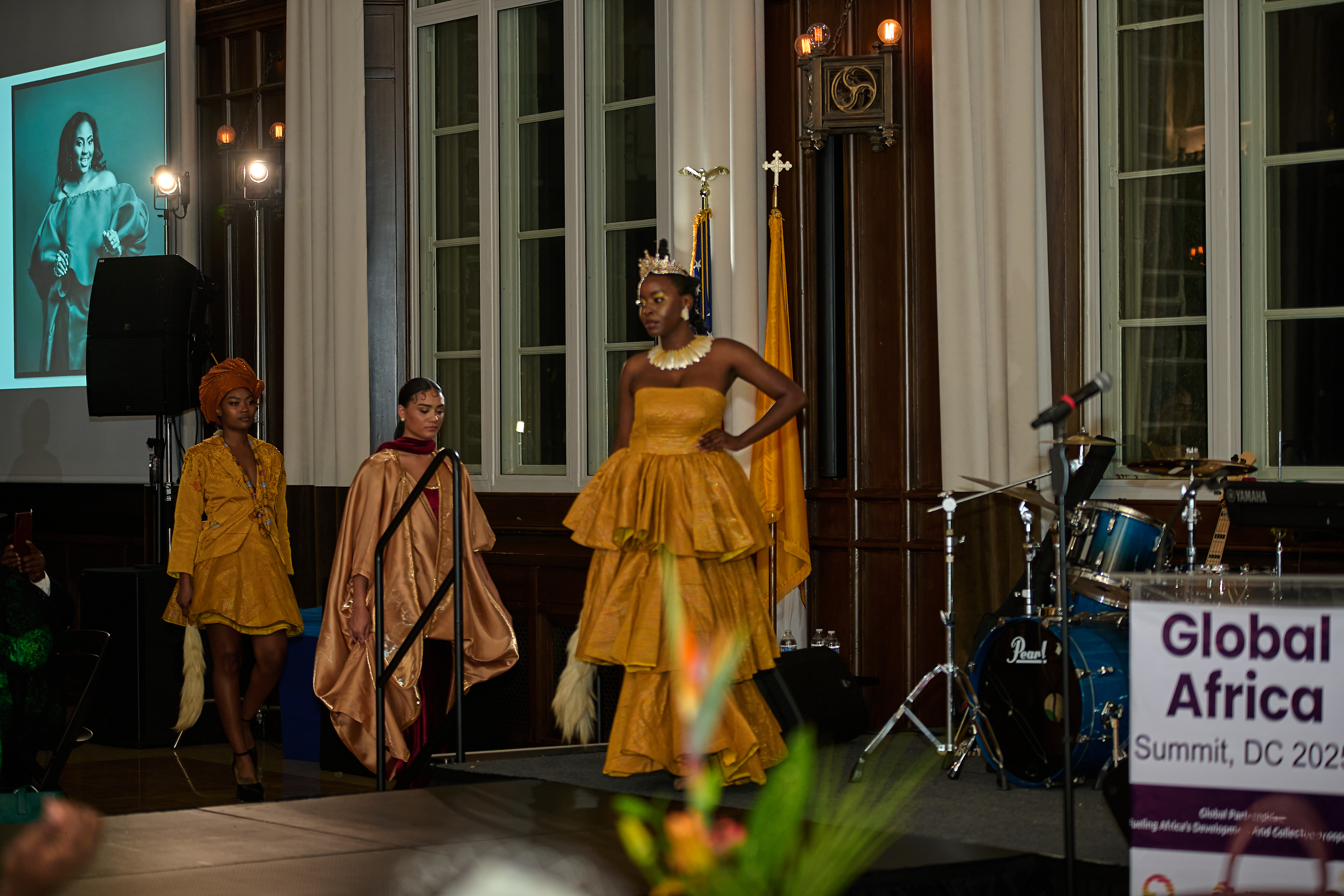 Models on stage in gold at a Global Africa Summit evening reception