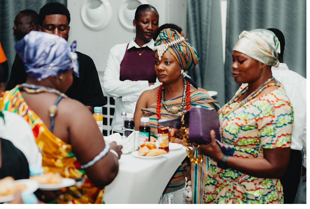 Members in traditional dress exchanging goods at a 6Africa gathering